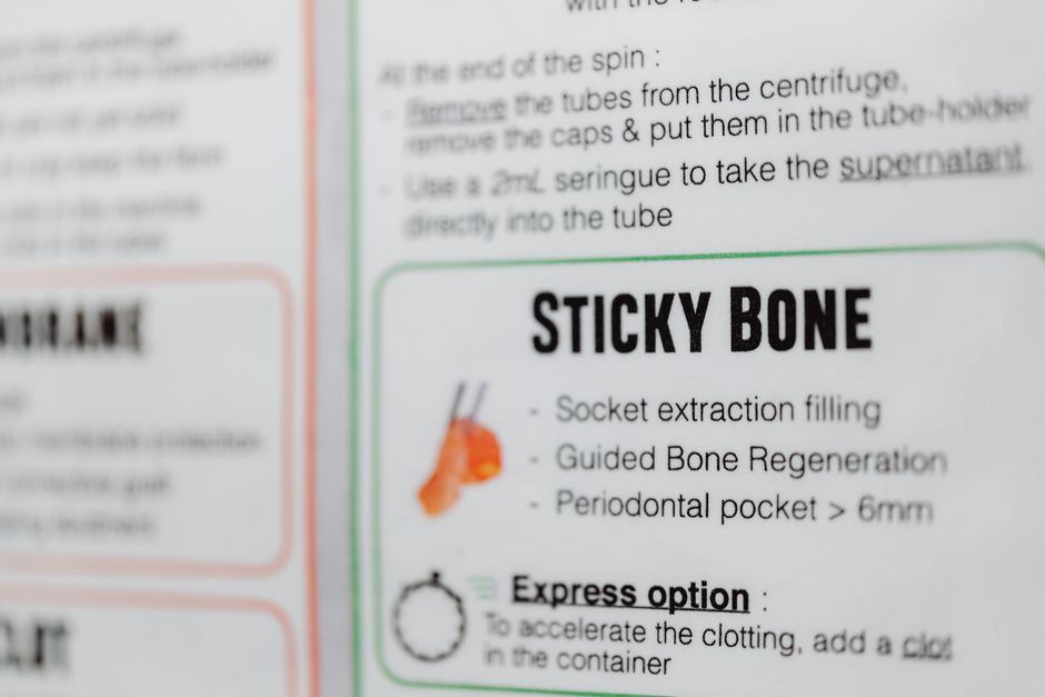 A close-up image of a printed informational sheet featuring a section titled 'STICKY BONE' with a small illustration of a tooth and related procedures such as socket extraction filling, guided bone re